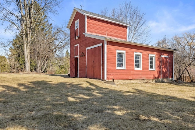 view of property exterior with an outdoor structure and a yard