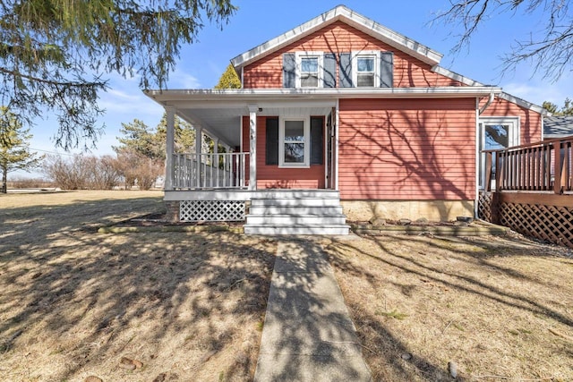 back of property with a yard and covered porch