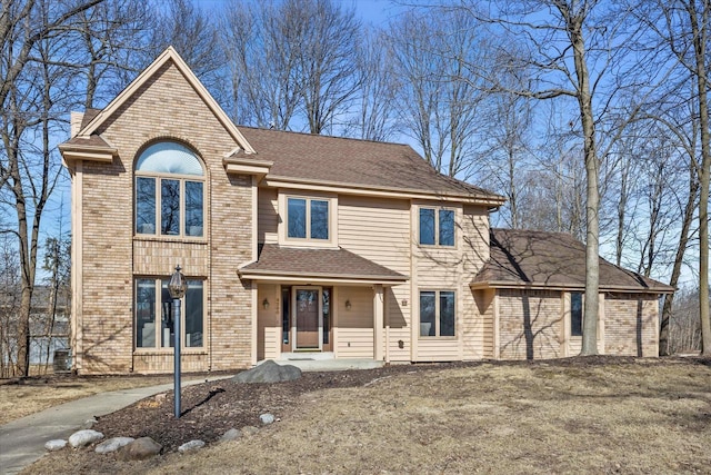 view of front of property with brick siding and a shingled roof