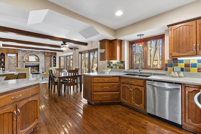 kitchen with a wealth of natural light, decorative backsplash, dark wood-type flooring, and stainless steel dishwasher