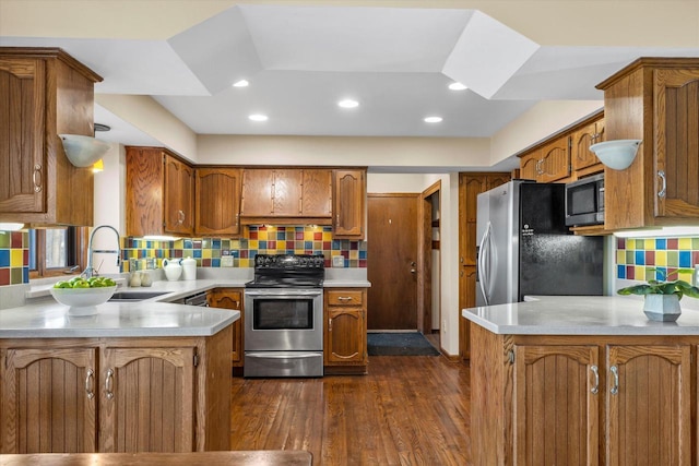 kitchen featuring dark wood-style floors, a sink, light countertops, appliances with stainless steel finishes, and brown cabinets