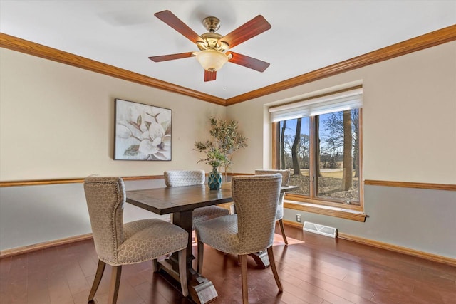 dining space featuring visible vents, crown molding, baseboards, and hardwood / wood-style floors