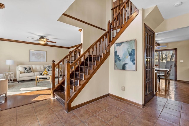 stairs featuring tile patterned flooring, crown molding, baseboards, and ceiling fan