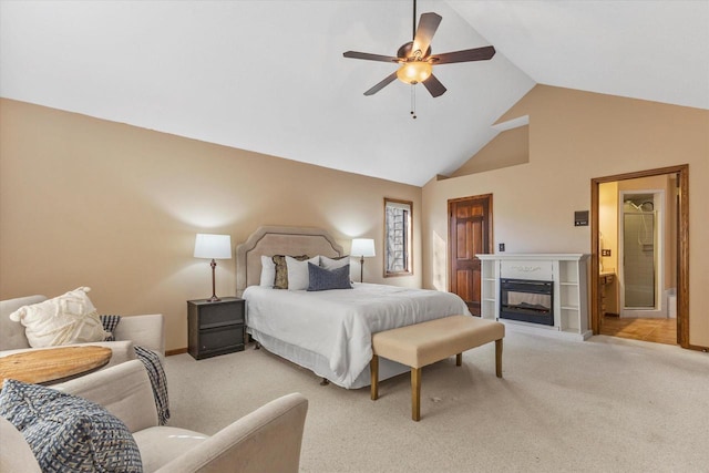 bedroom featuring baseboards, high vaulted ceiling, ceiling fan, a glass covered fireplace, and light colored carpet