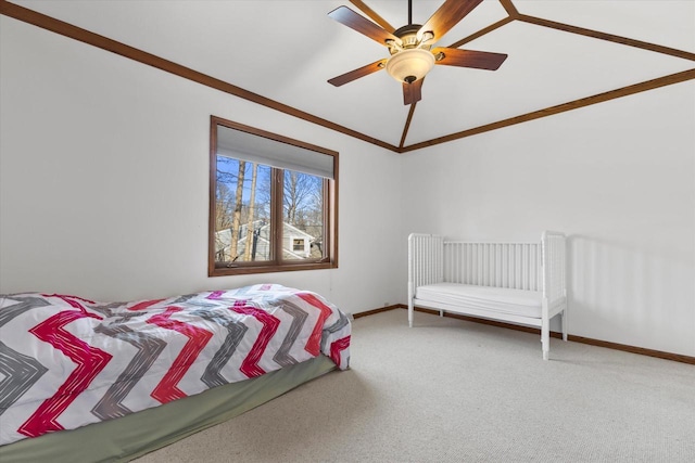 carpeted bedroom featuring a ceiling fan, crown molding, baseboards, and vaulted ceiling