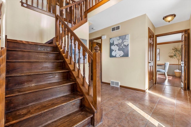 stairs with tile patterned flooring, visible vents, and baseboards