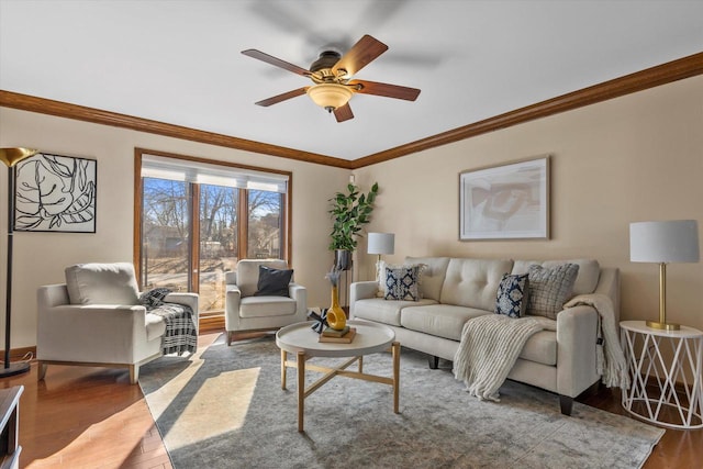 living room with ceiling fan, baseboards, wood finished floors, and ornamental molding