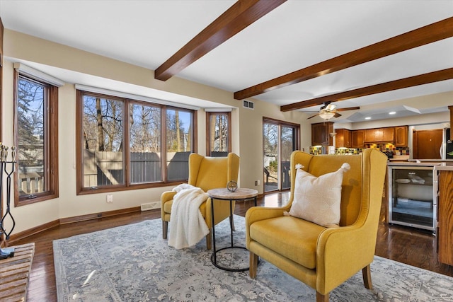 living area featuring visible vents, beamed ceiling, beverage cooler, dark wood-style floors, and baseboards