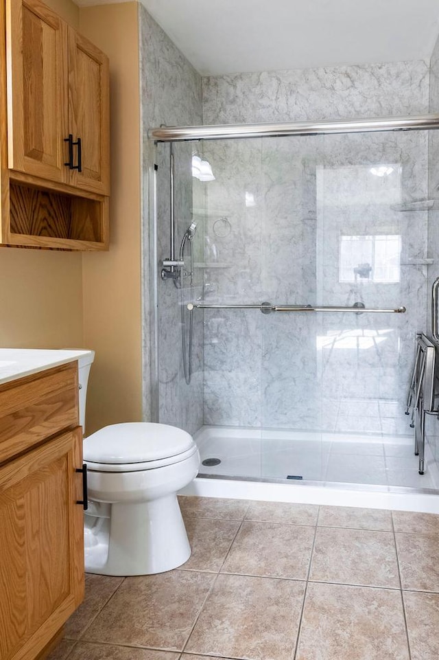 full bathroom featuring tile patterned flooring, vanity, a shower stall, and toilet