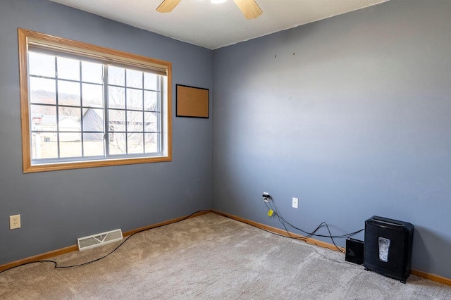 carpeted empty room featuring visible vents, baseboards, and a ceiling fan