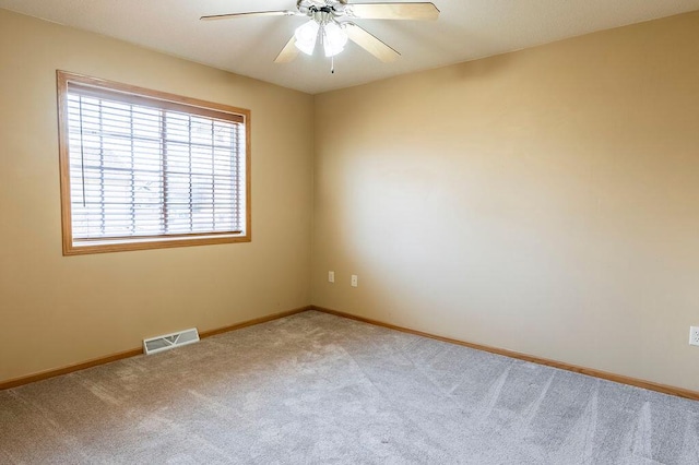 unfurnished room featuring a ceiling fan, light colored carpet, visible vents, and baseboards