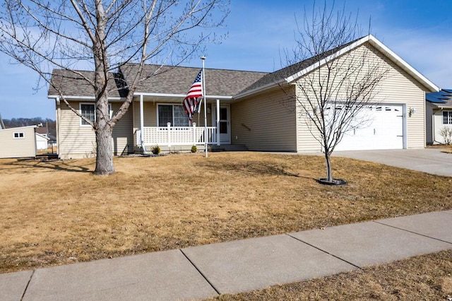 ranch-style house featuring a front lawn, an attached garage, covered porch, and driveway