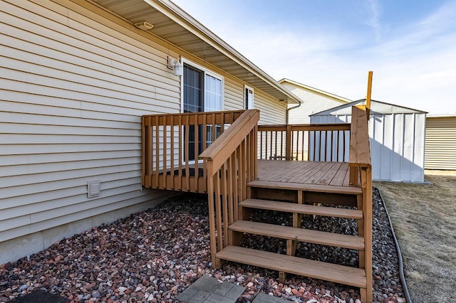 wooden deck with a storage unit and an outbuilding