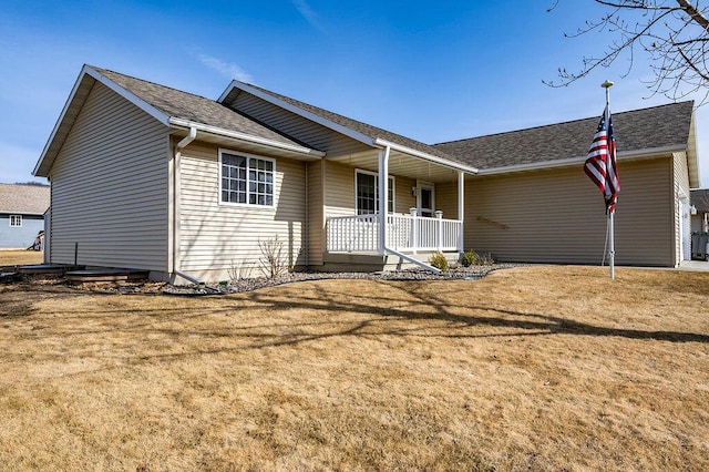 ranch-style home featuring covered porch, a front lawn, and a shingled roof