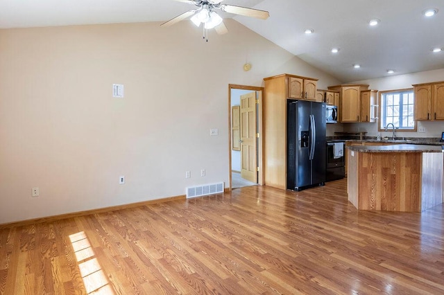 kitchen featuring visible vents, range with electric cooktop, stainless steel microwave, light wood-style floors, and black fridge with ice dispenser