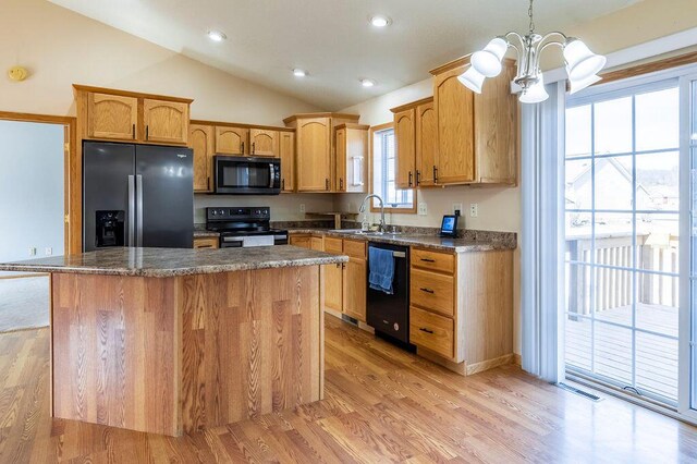 kitchen featuring a center island, lofted ceiling, a notable chandelier, black appliances, and a sink