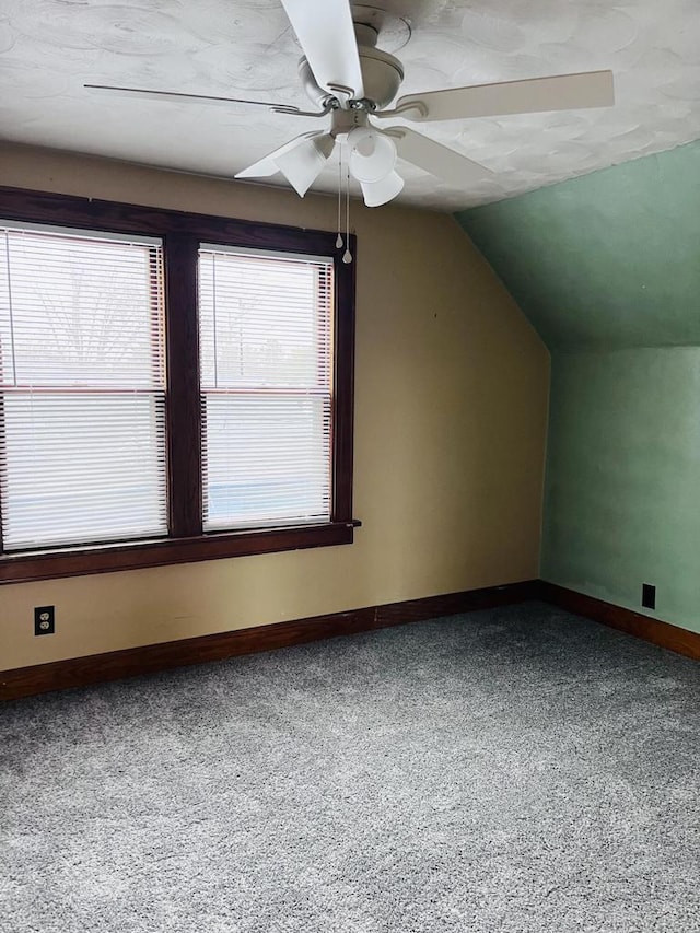 additional living space with baseboards, lofted ceiling, and a ceiling fan