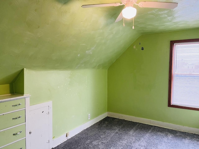 additional living space with lofted ceiling, a ceiling fan, baseboards, and dark carpet