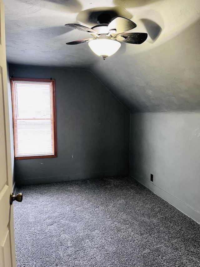 bonus room featuring lofted ceiling, carpet flooring, and ceiling fan