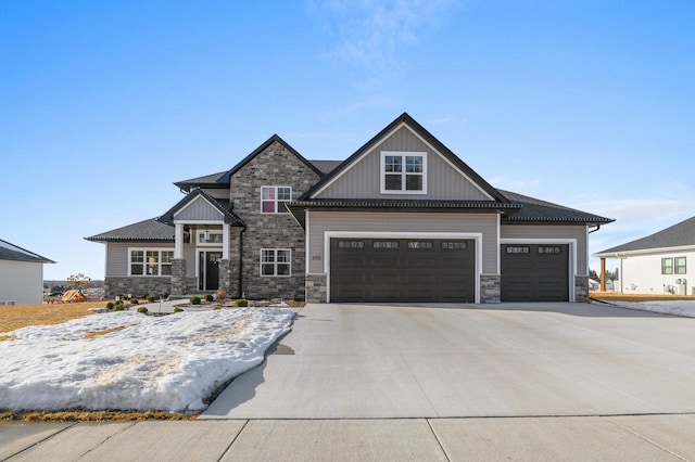 craftsman-style home with board and batten siding, concrete driveway, and stone siding