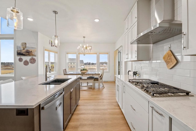 655 Sunset Grn, Bay, WI 54313 - kitchen featuring light wood-style flooring, a sink, stainless steel appliances, wall chimney exhaust hood, and a healthy amount of sunlight