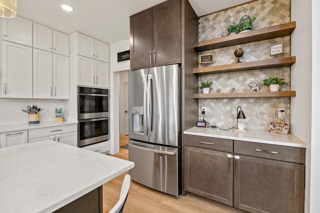 655 Sunset Grn, Bay, WI 54313 - kitchen with stainless steel appliances, dark brown cabinets, decorative backsplash, and white cabinetry