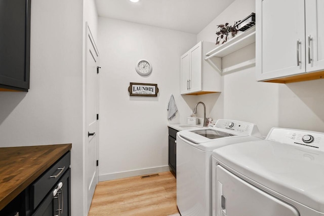655 Sunset Grn, Bay, WI 54313 - clothes washing area featuring washer and clothes dryer, a sink, cabinet space, light wood-style floors, and baseboards