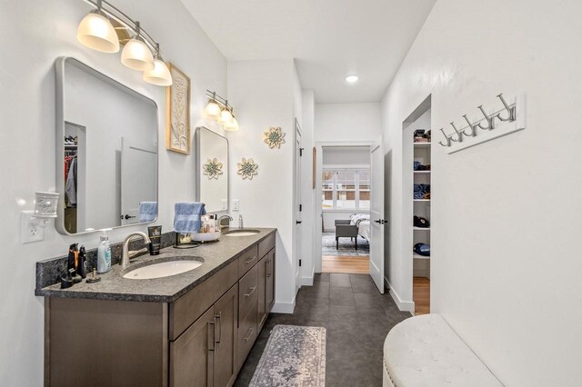 655 Sunset Grn, Bay, WI 54313 - bathroom featuring a sink, baseboards, double vanity, and a spacious closet