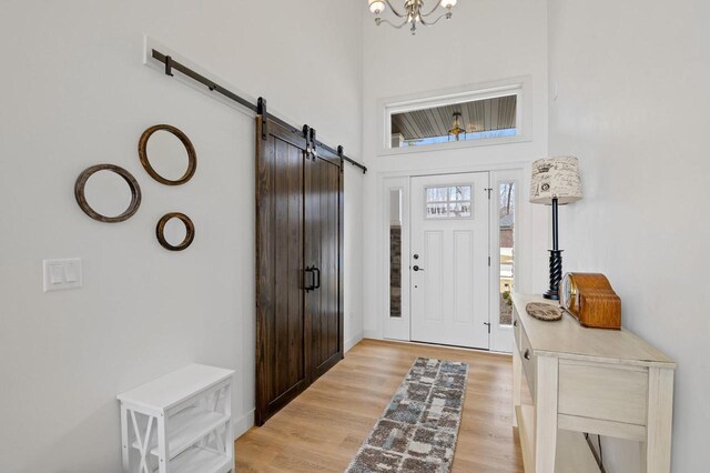 655 Sunset Grn, Bay, WI 54313 - foyer entrance with an inviting chandelier, light wood-style floors, a barn door, and a towering ceiling