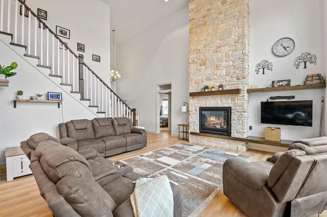 655 Sunset Grn, Bay, WI 54313 - living room with baseboards, stairs, a stone fireplace, a high ceiling, and wood finished floors