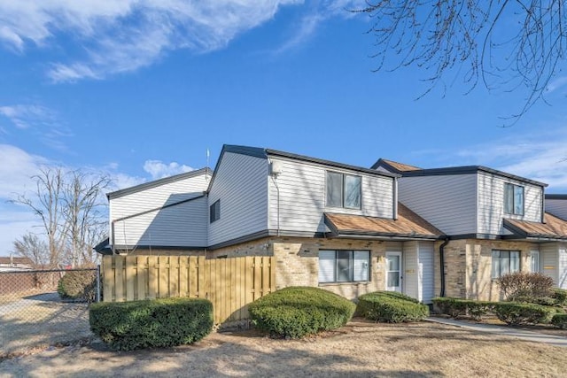 view of front of home featuring brick siding and fence