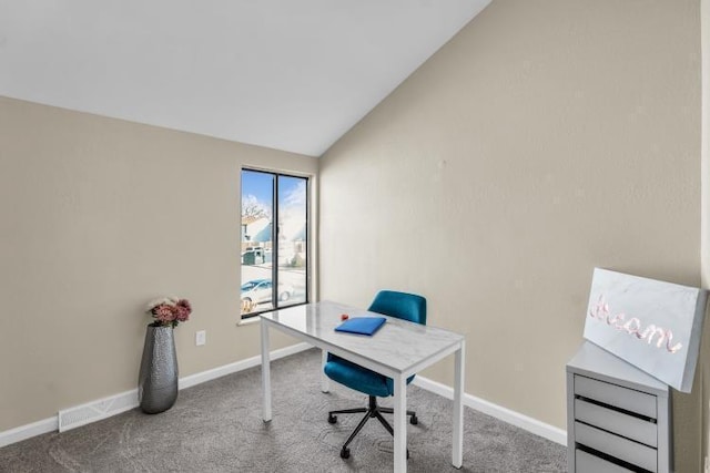 carpeted office featuring visible vents, baseboards, and vaulted ceiling