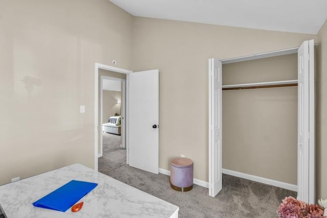 bedroom featuring a closet, carpet flooring, baseboards, and lofted ceiling