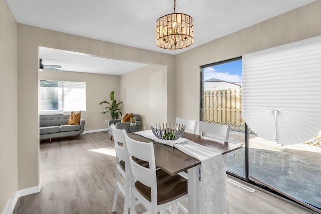 dining space featuring wood finished floors, baseboards, and a chandelier