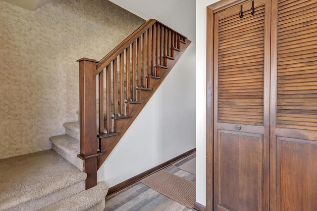 staircase with baseboards and wood finished floors