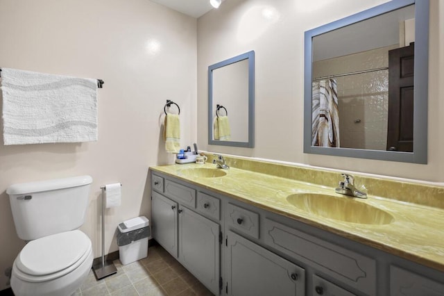 full bathroom featuring a sink, tiled shower, toilet, and double vanity