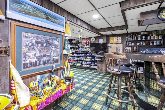 interior space featuring carpet flooring, a bar, and a paneled ceiling