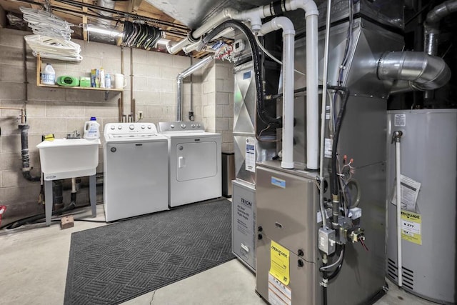 washroom featuring laundry area, gas water heater, a sink, and separate washer and dryer