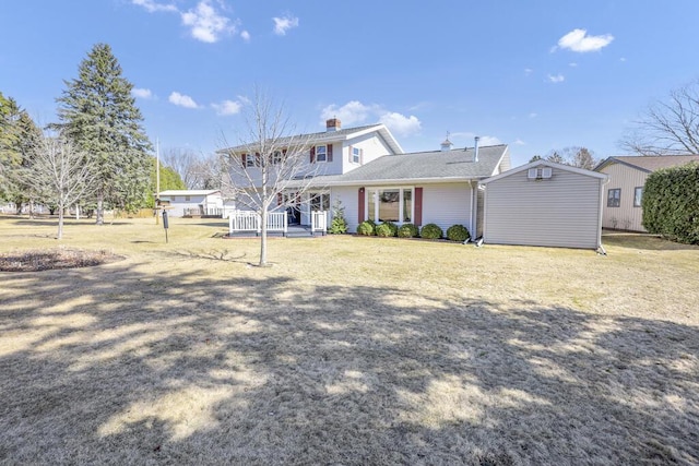 back of property with a lawn, covered porch, and a chimney