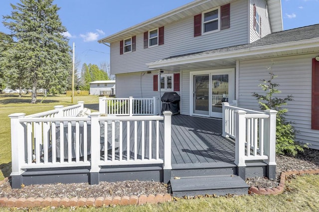 wooden terrace featuring a grill and a yard