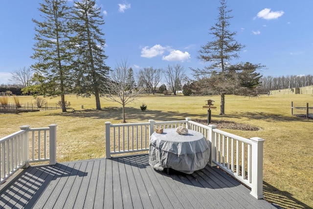 wooden deck with a rural view and a lawn