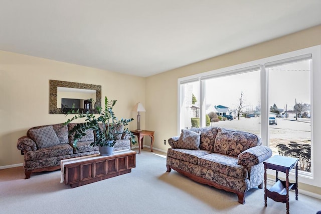 carpeted living area featuring baseboards