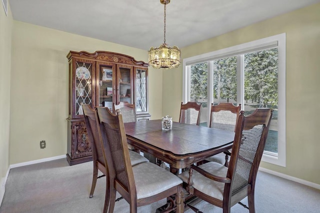 dining area featuring a chandelier, light carpet, and baseboards