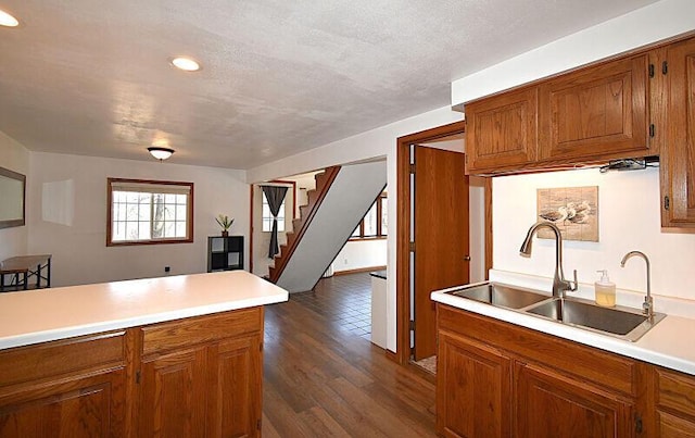 kitchen with light countertops, brown cabinetry, and a sink