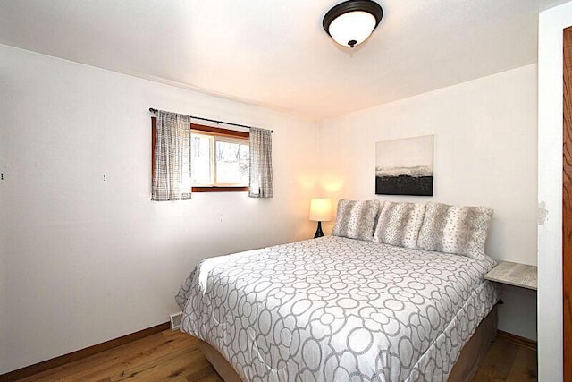 bedroom with baseboards and wood finished floors