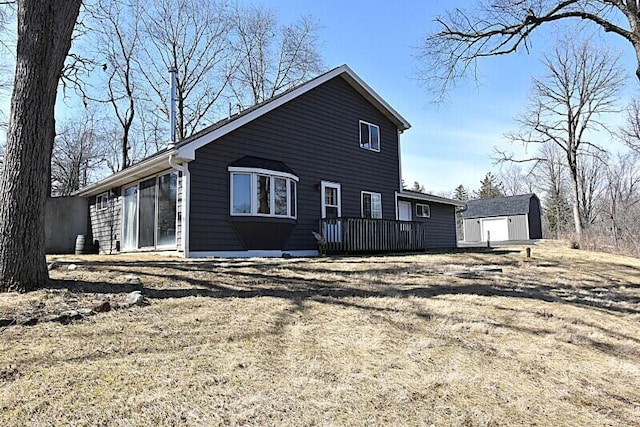 rear view of house featuring an outbuilding and a deck