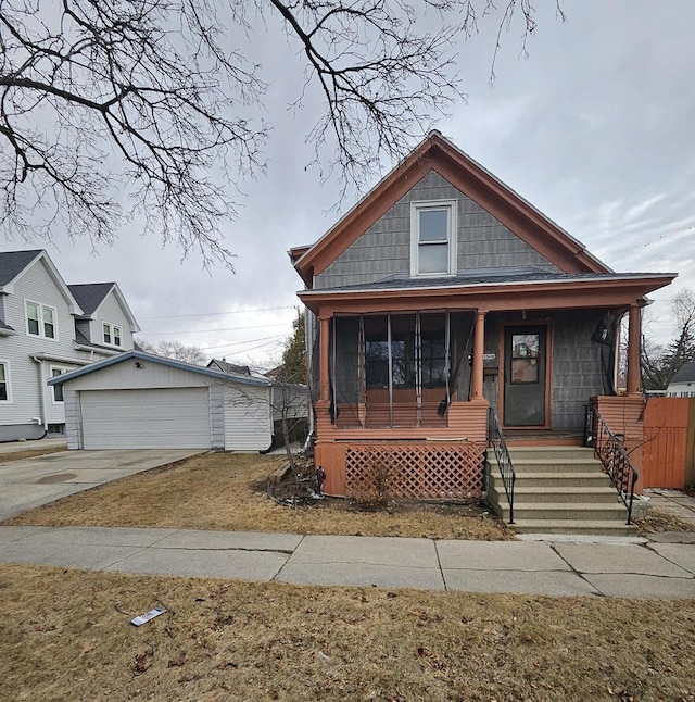 view of front facade with covered porch, a detached garage, and an outdoor structure