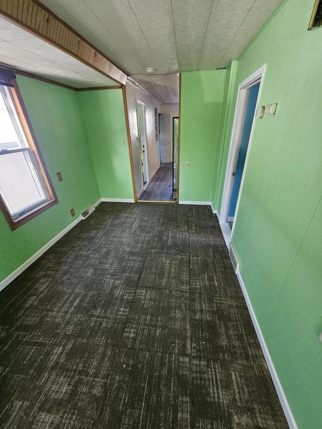 spare room featuring visible vents, baseboards, and carpet floors