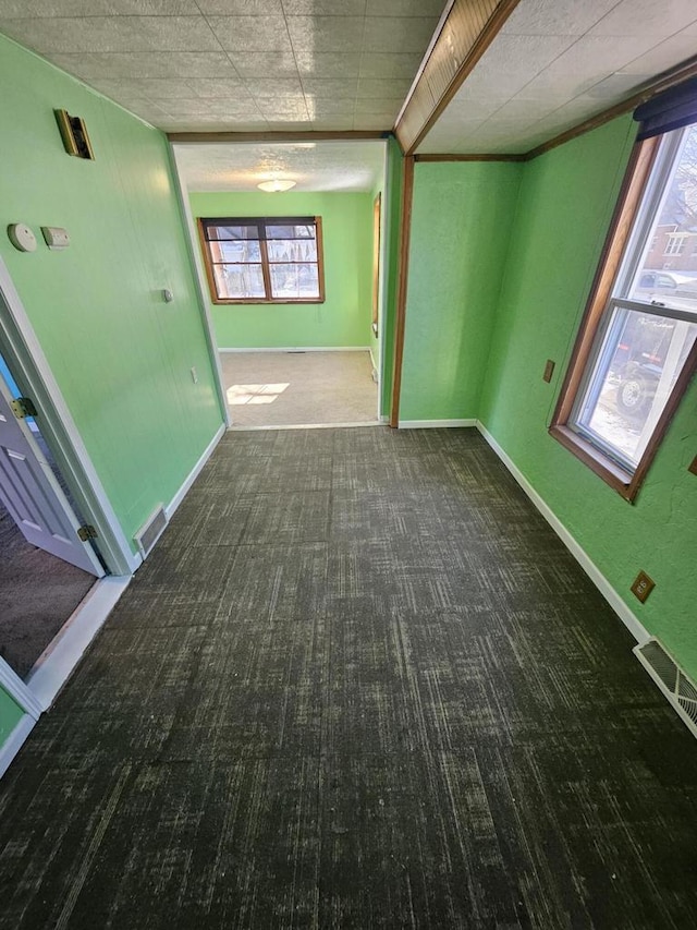 carpeted spare room featuring stairs, baseboards, and visible vents