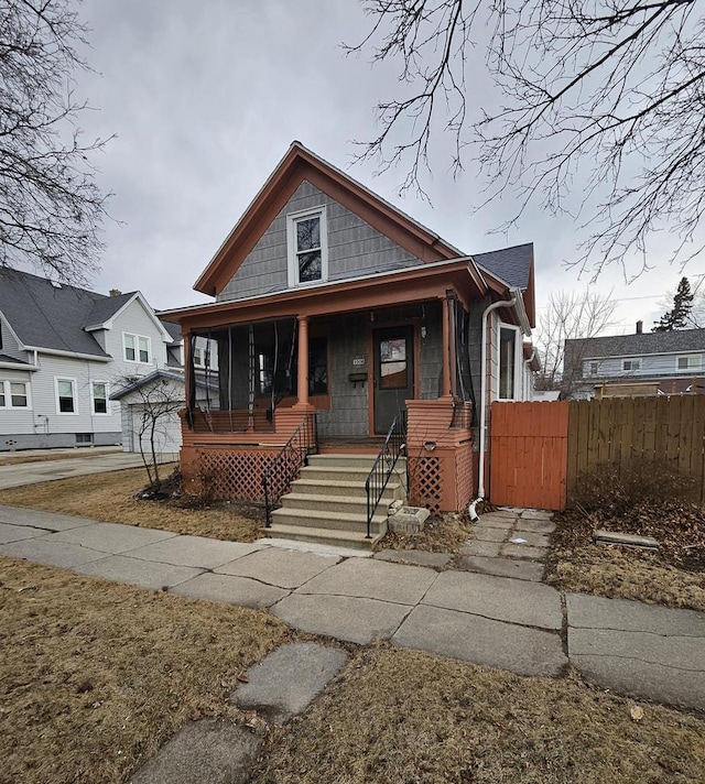 view of front of property with a gate, a porch, and fence